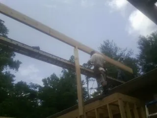 Carpenter setting a ridge beam over a new addition frame — Ice Dam Removal by Roofing Brothers in South Beloit