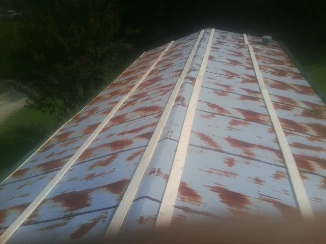 Rusted metal roof panels with new wood purlins before replacement — Storm Damage Roof Repair in South Beloit by Roofing Brothers