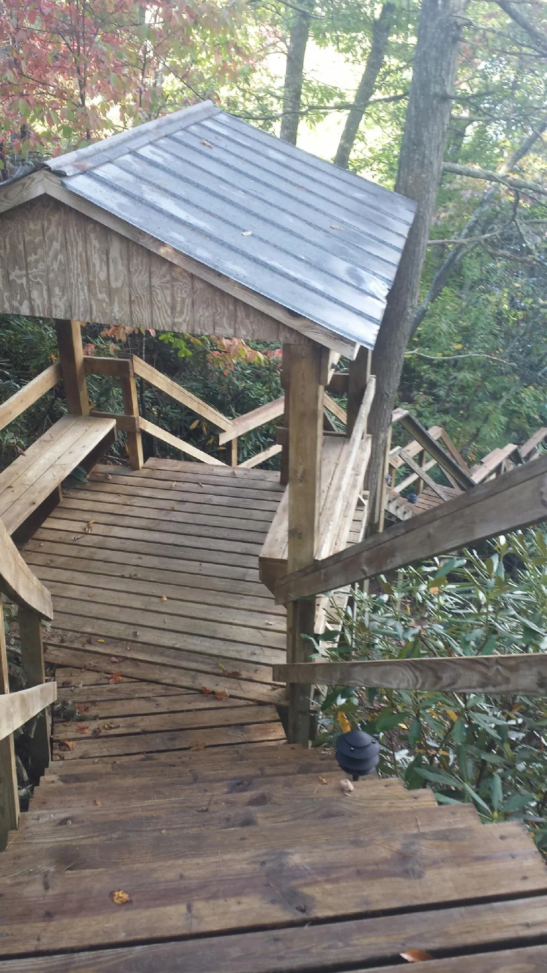 Metal roofed shelter over wooden steps on a wooded walkway — Skylight Repair & Installation work by our crew in South Beloit