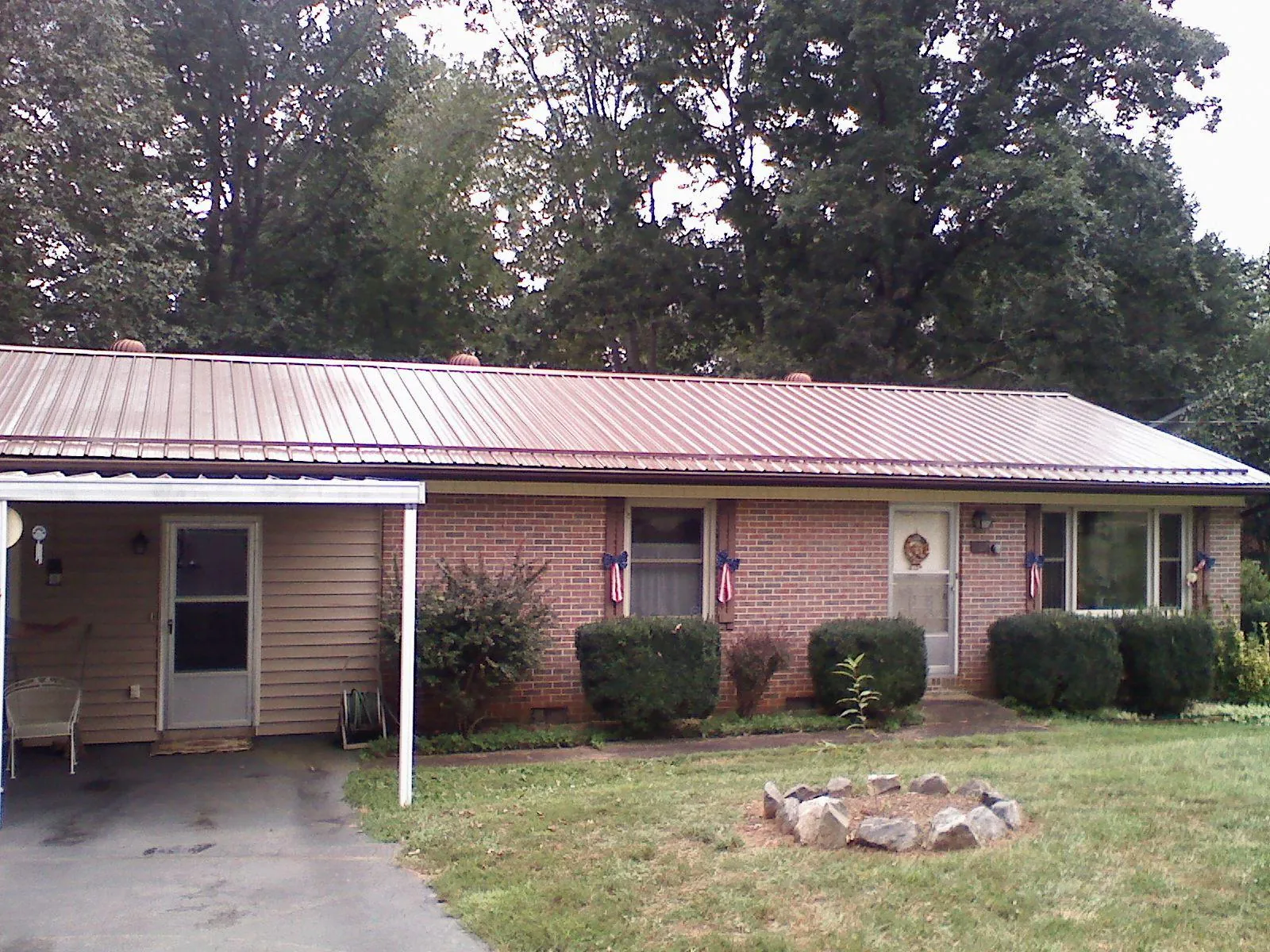 Bronze metal roof and carport on a brick ranch home — Roof Repair work by our crew in South Beloit